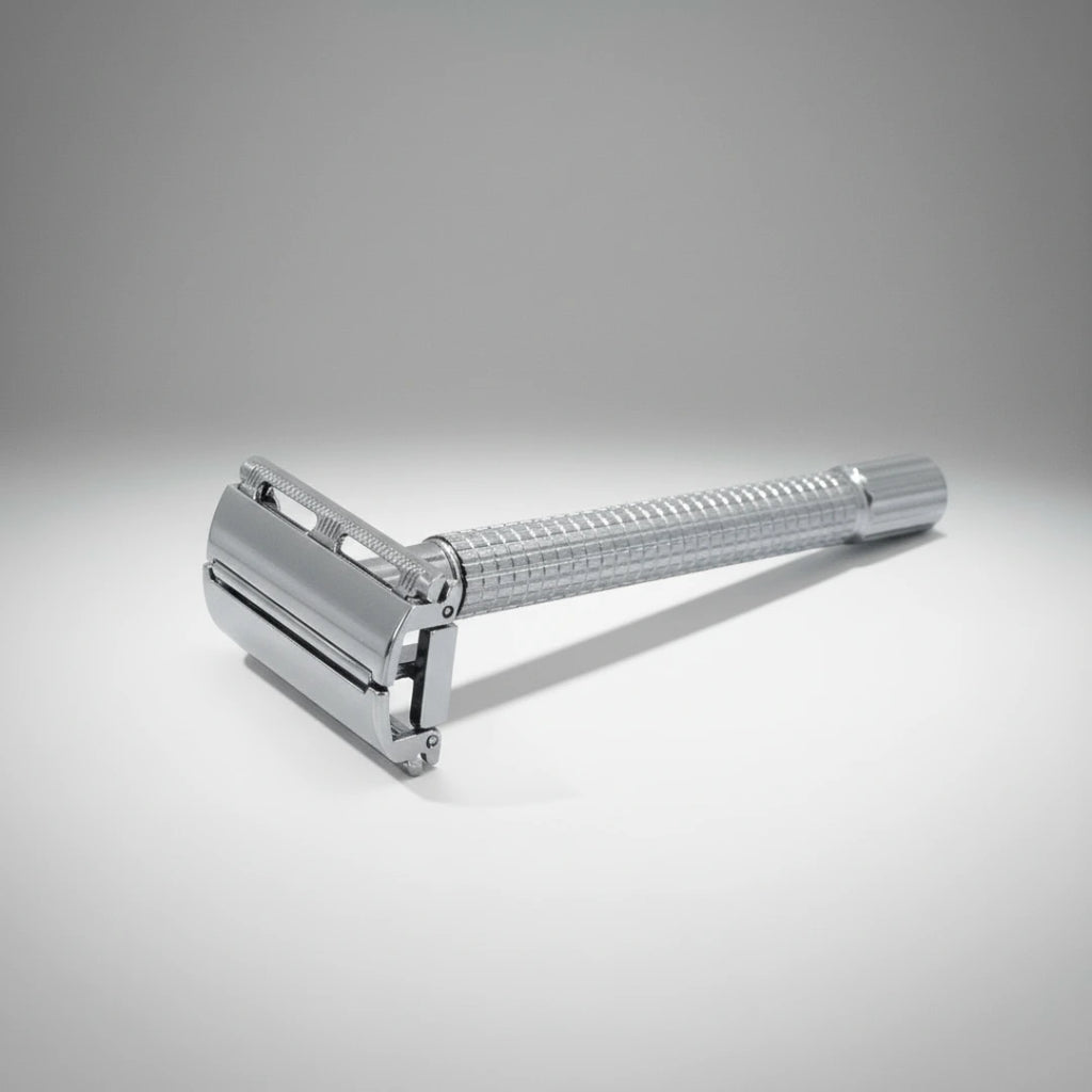 Gros plan sur la tête d'un rasoir de sûreté à ouverture papillon chrome. Manche travaillé pour une prise en main antidérapante.