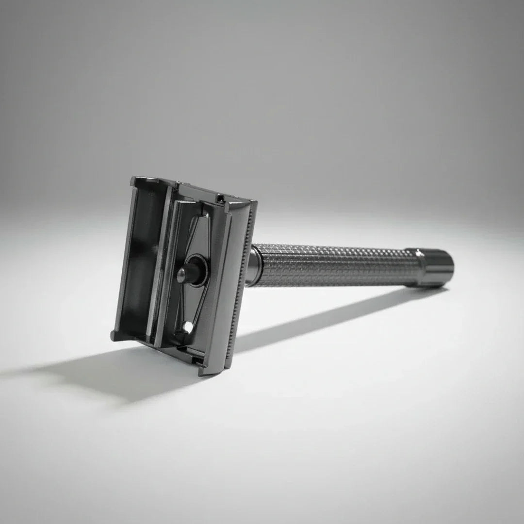 Rasoir de sûreté gunmetal à ouverture "papillon" déployé pour un remplacement facile et sécurisé de la lame de rasoir.