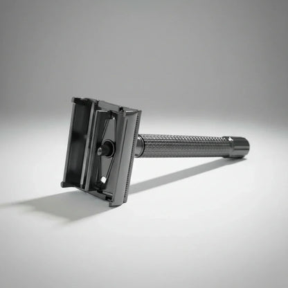 Rasoir de sûreté gunmetal à ouverture "papillon" déployé pour un remplacement facile et sécurisé de la lame de rasoir.