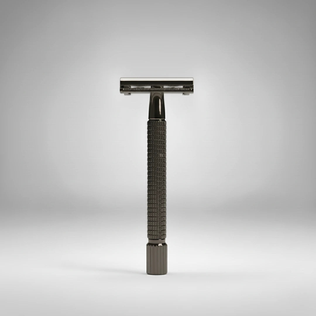 Rasoir de sûreté traditionnel à ouverture papillon gunmetal. Posé verticalement sur un fond gris épuré. Idéal pour un rasage traditionnel élégant.