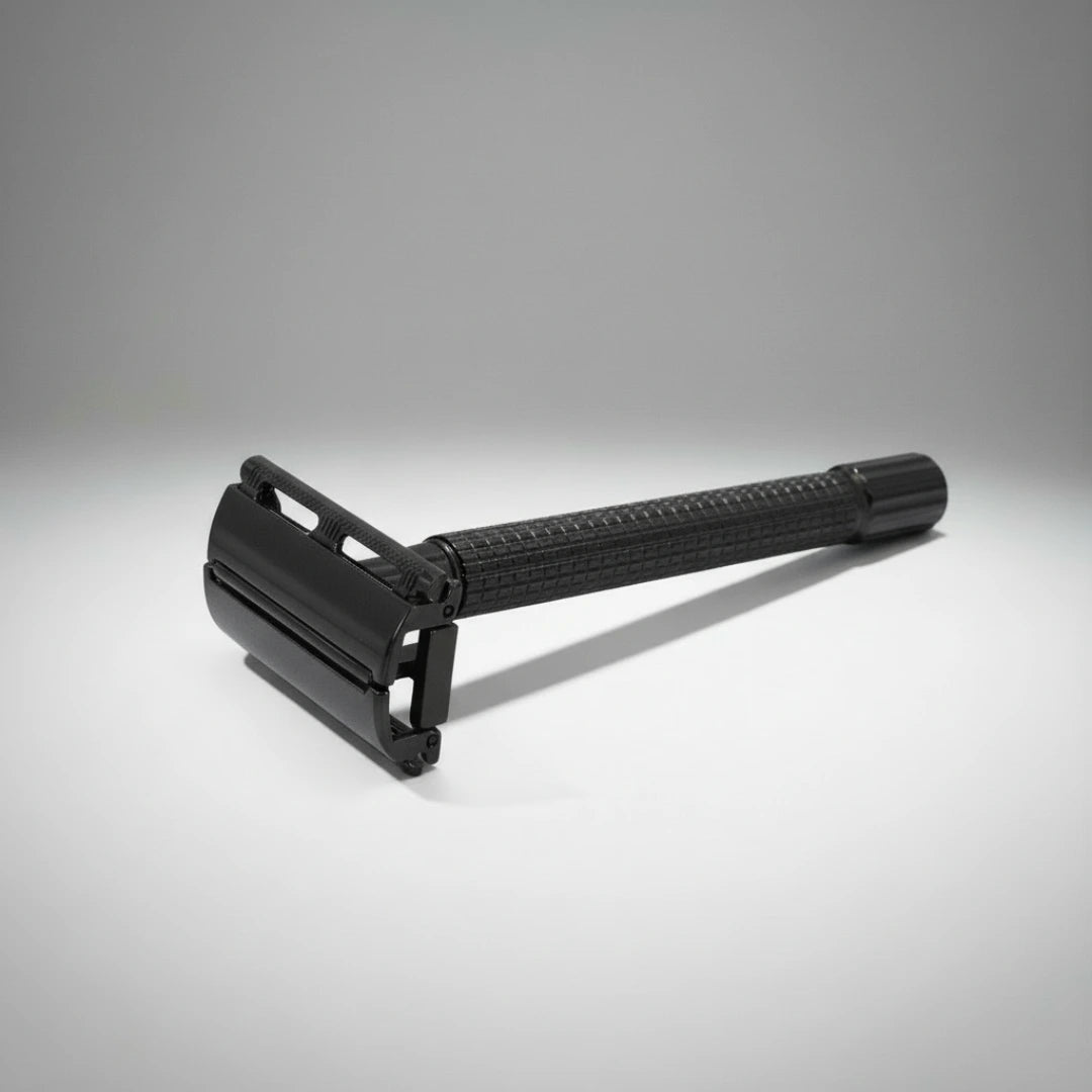 Gros plan sur la tête d'un rasoir de sûreté à ouverture papillon noir. Manche travaillé pour une prise en main antidérapante.