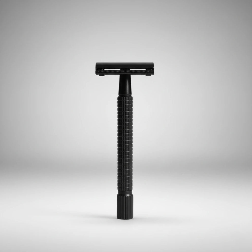 Rasoir de sûreté traditionnel à ouverture papillon noir. Posé verticalement sur un fond gris épuré. Idéal pour un rasage traditionnel élégant.